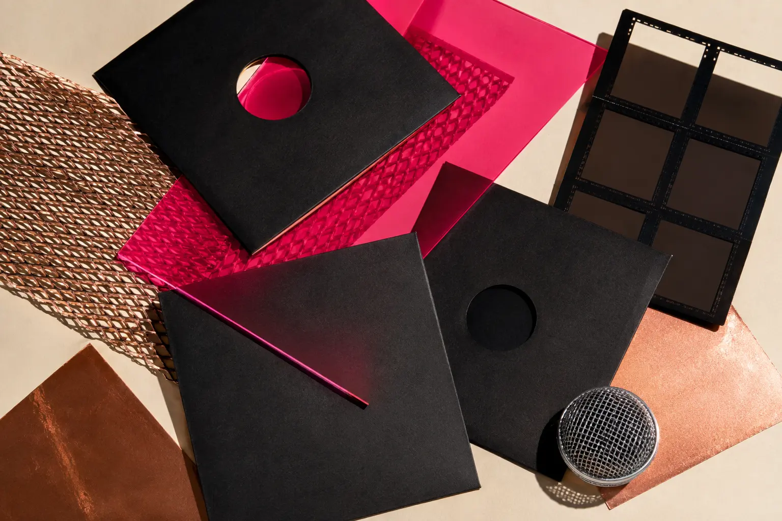 Blank black record sleeves, fuchsia acetate, copper mesh and a chrome microphone grille